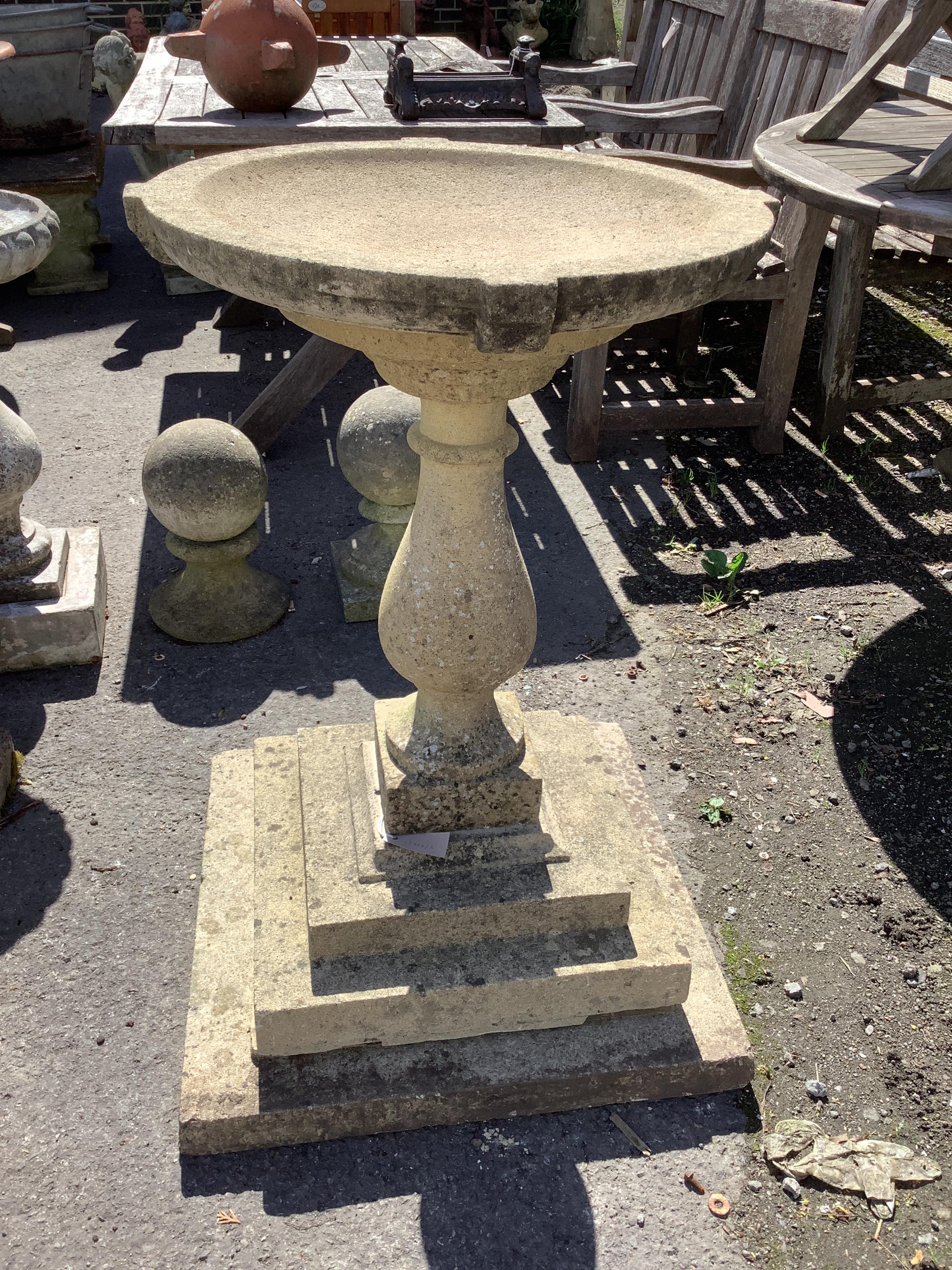 A circular stone baluster bird bath on stepped square base, height 87cm